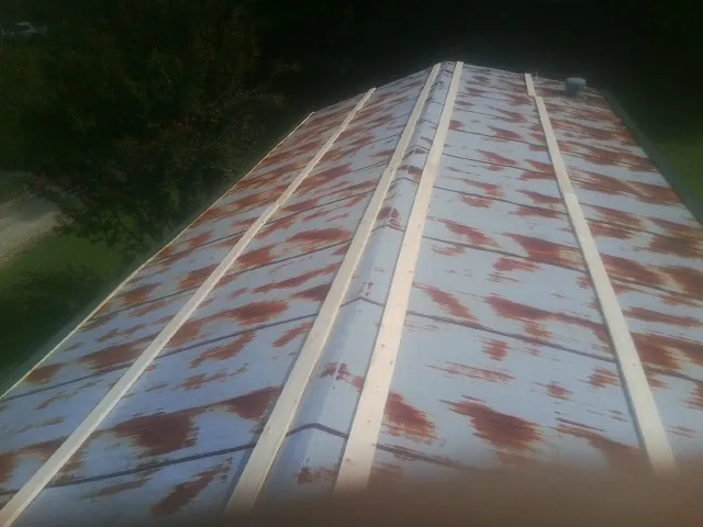 Rusted metal roof panels with new wood purlins before replacement — Storm Damage Roof Repair in Saint Martinville by Roofing Brothers