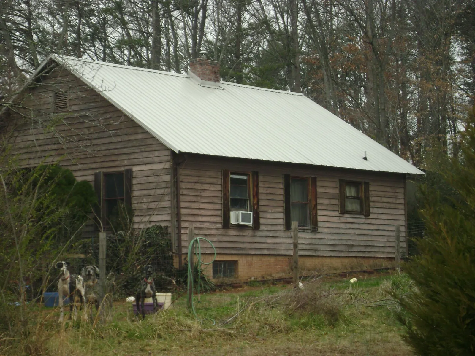 White metal roof on an old wood sided farmhouse, from a Asphalt Shingle Roof Repair job in Saint Martinville